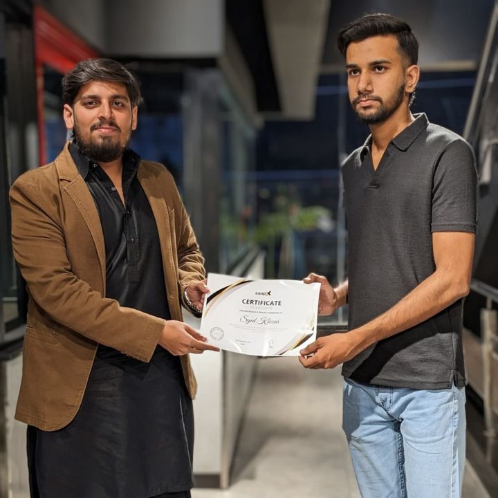 A Saapx team member receiving a certificate from company leadership